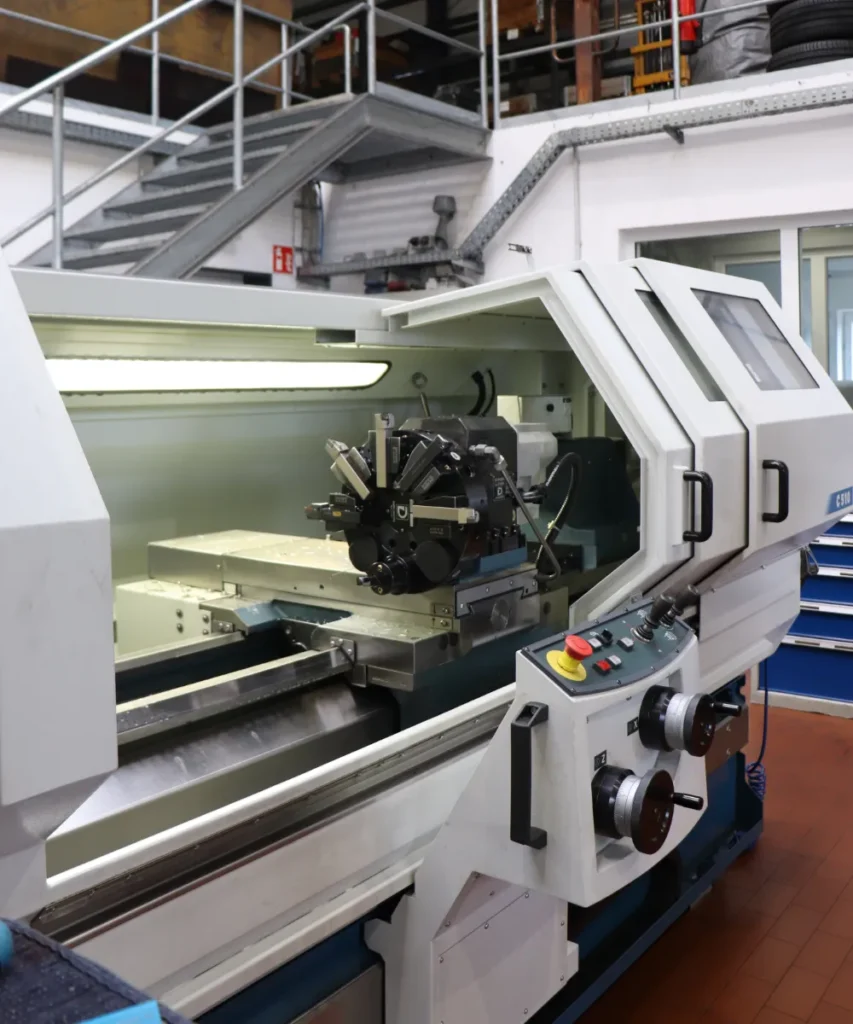 CNC-Drehmaschine mit geöffneter Schutztür in der Motoreninstandsetzungs-Werkstatt
