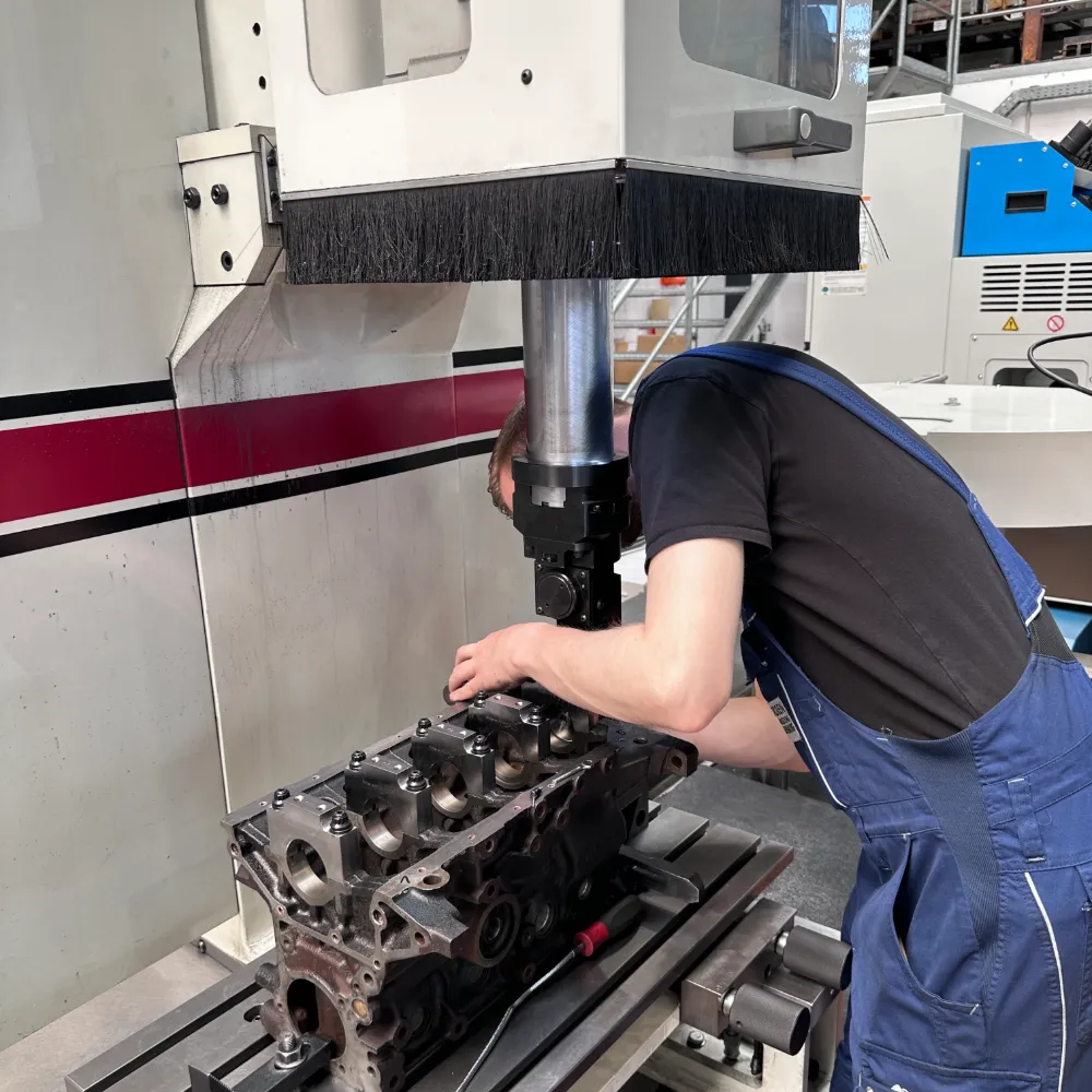 Mitarbeiter richtet einen Motorblock zur CNC-Bearbeitung ein